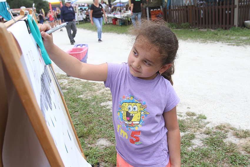 Edith Flores draws on a canvas.