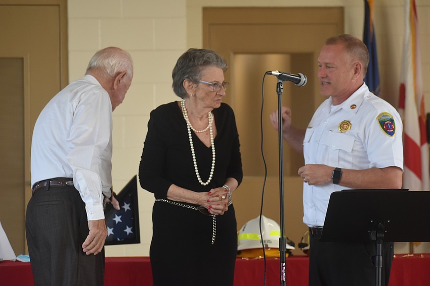 Former East Manatee Fire Rescue District Commissioner Don O'Leary and his wife, Audrey O'Leary, receive the first flag to ever fly over East Manatee Station 8 from East Manatee Fire Rescue District Chief Lee Whitehurst.