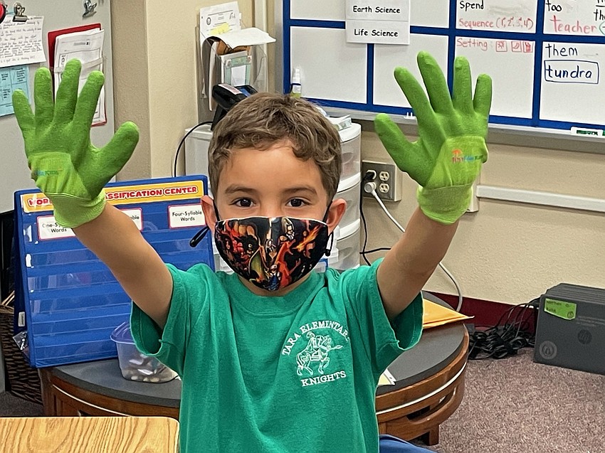 Landon Flores, a kindergartner at Tara Elementary School, is excited to receive his own garden gloves. A grant helped fund the purchase of gloves, soil, seeds and more. Courtesy photo.