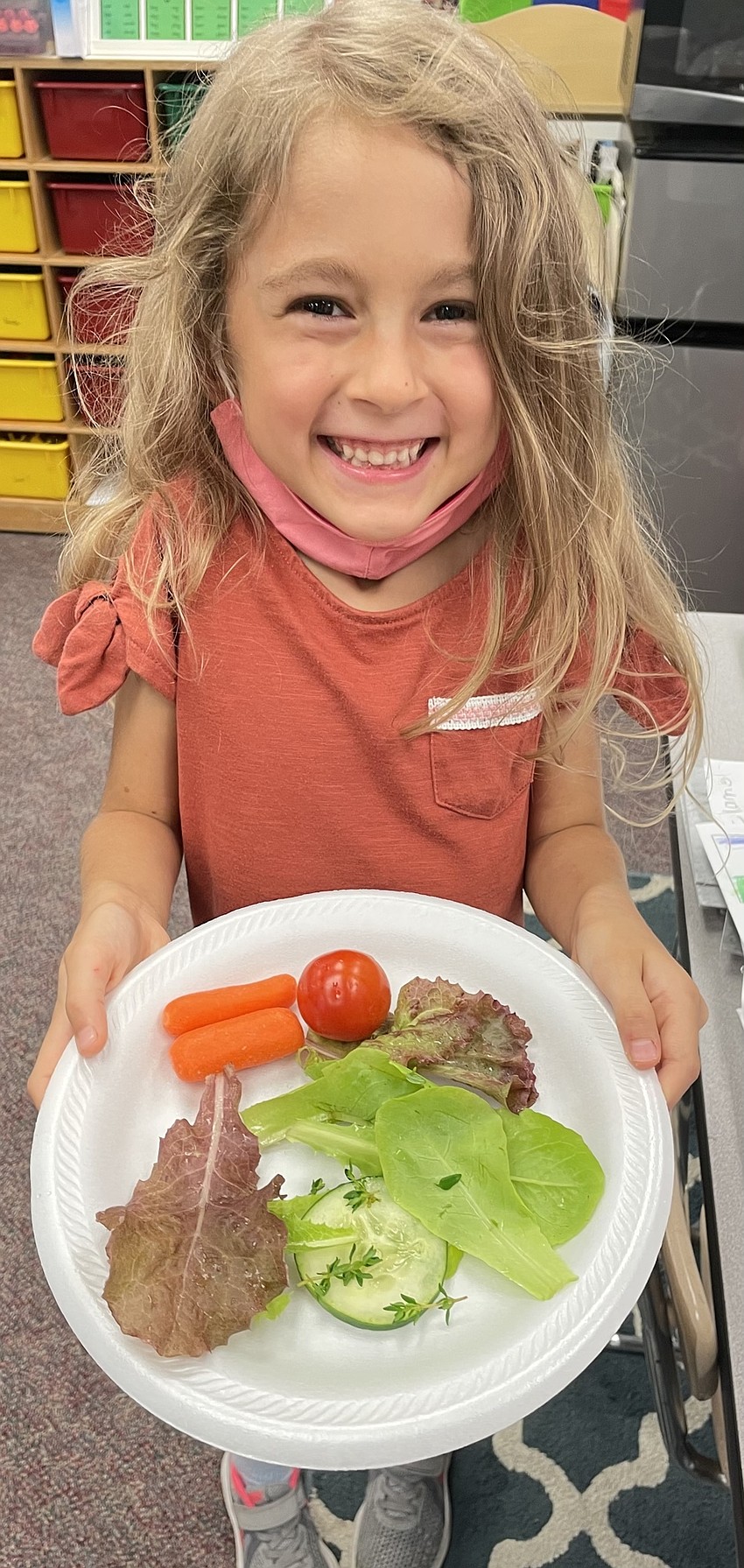 Emily Weathers, a kindergartner at Tara Elementary School, tries herbs, lettuce, carrots and tomatoes grown in the school's garden.