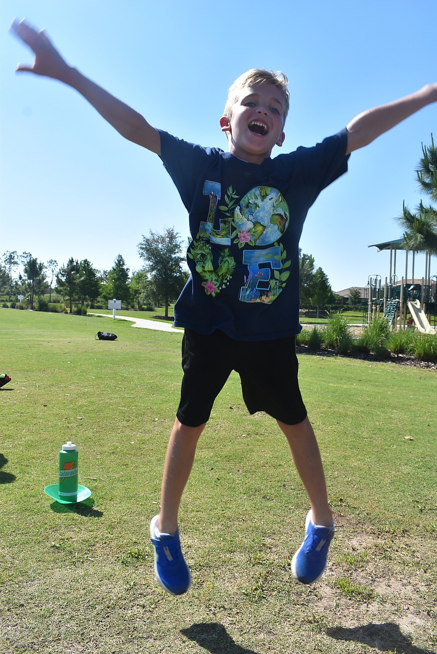 Central Park resident Connor Biegel, 7, jumps after being energized by a water break. He says his favorite part of Fit4Kids is running all over the park.