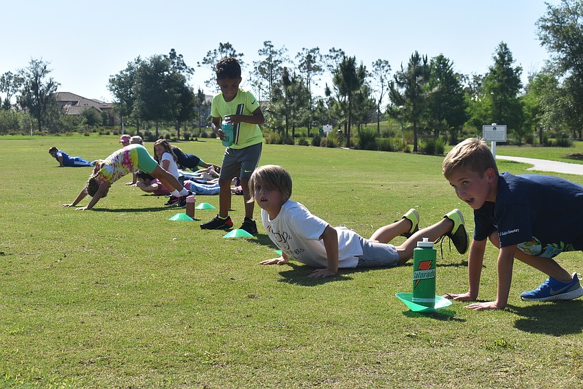 Fit4Kids participants do push-up drills before starting sprints. Instructor Graham Anderson's call of 