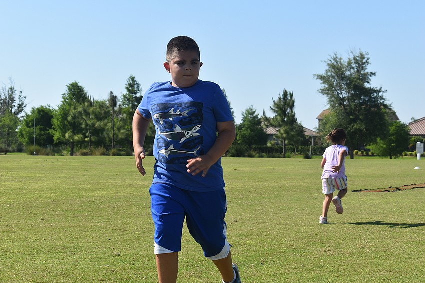 Lakewood Ranch resident Mason Dennis runs from one end of the park to the other, as Greyhawk Landing's Marlie Brooks runs to the other side of the field. Instructor Graham Anderson said Dennis has made progress in his running.