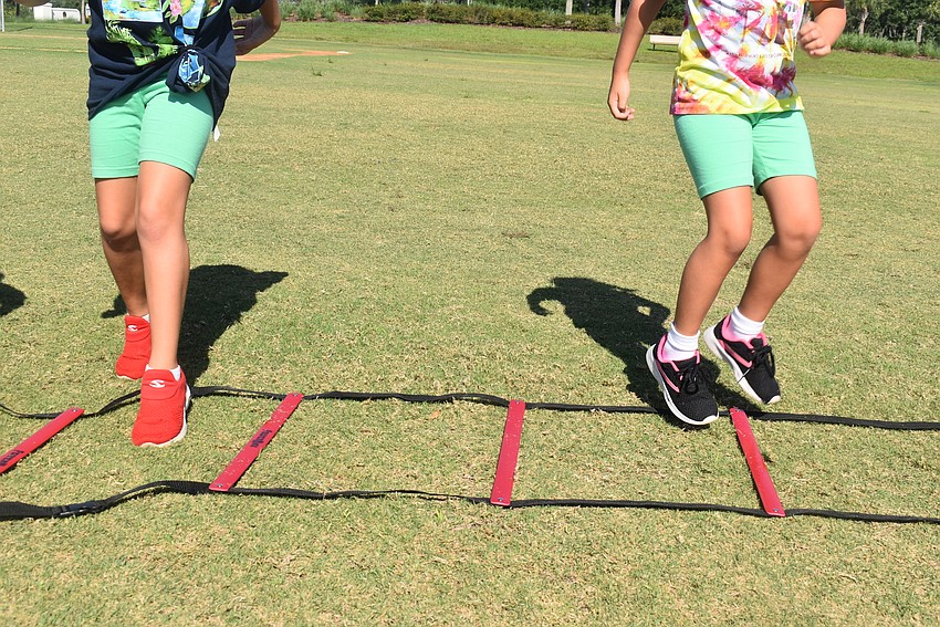 Lakewood Ranch residents Lilah Santiago and Aria Volpe do toe taps on the ladder. Volpe says her favorite parts of Fit4Kids are jumping jacks and push-ups.