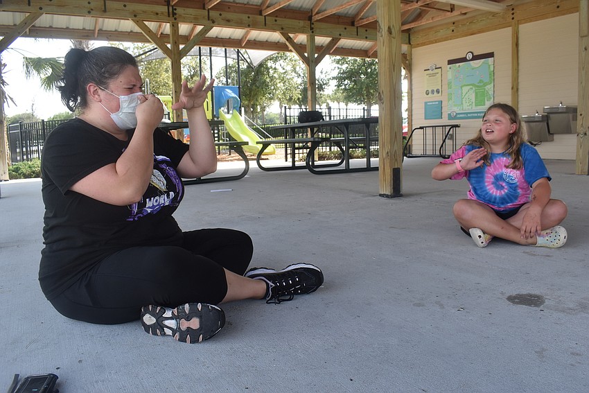 Acting coach Alyssa Goudy, who works for The Players Centre for Performing Arts, makes the signal for participants to imitate a skunk while Greenbrook resident Nahla Vlasak, 9, prepares to act like the animal Goudy signals.