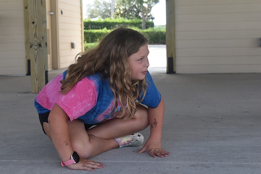 Greenbrook resident Nahla Vlasak, 9, plays King Frog during the game of the same name. The game involves each player choosing an animal and others imitating that animal.