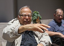 Dick Johnson lets a butterfly rest on his hand.