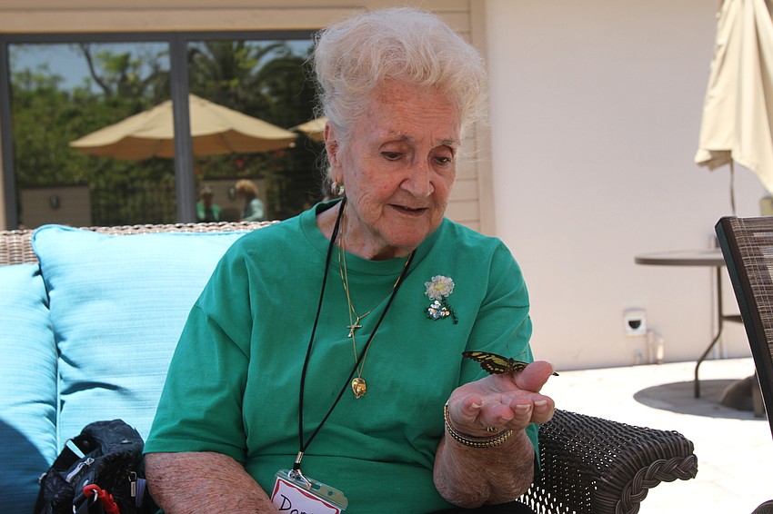 Doris Wozniak handles a butterfly.