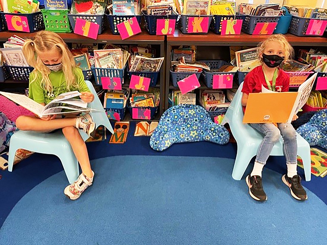 Paige Royce and Emma Curry, first graders at Braden River Elementary School, sit quietly while reading. The school district says changes to the calendar next year will help address the learning gap in reading. Courtesy photo.
