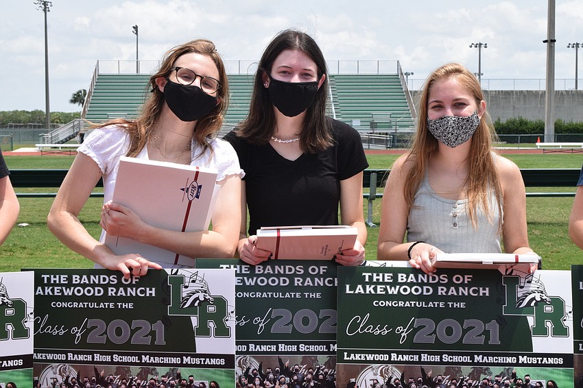 Seniors Alexis Rister, Alicia Torres and Mallory Shirey are honored at the band picnic. They received awards, yard signs and certificates for their participation in the band.