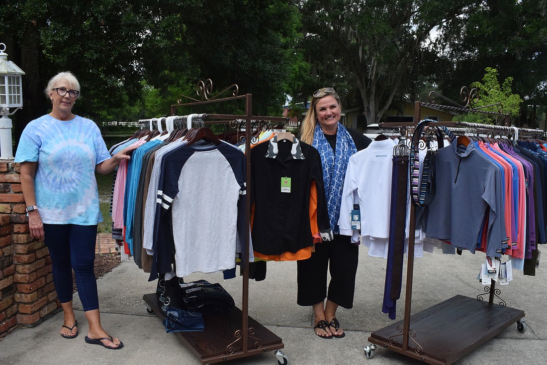 Stacey Volpe, the administrative coordinator for Sarasota Manatee Association for Riding Therapy, and Rebecca Blitz, the nonprofit&#39;s executive director, showcase some of the items EquiElite Boutique donated for the tack sale.