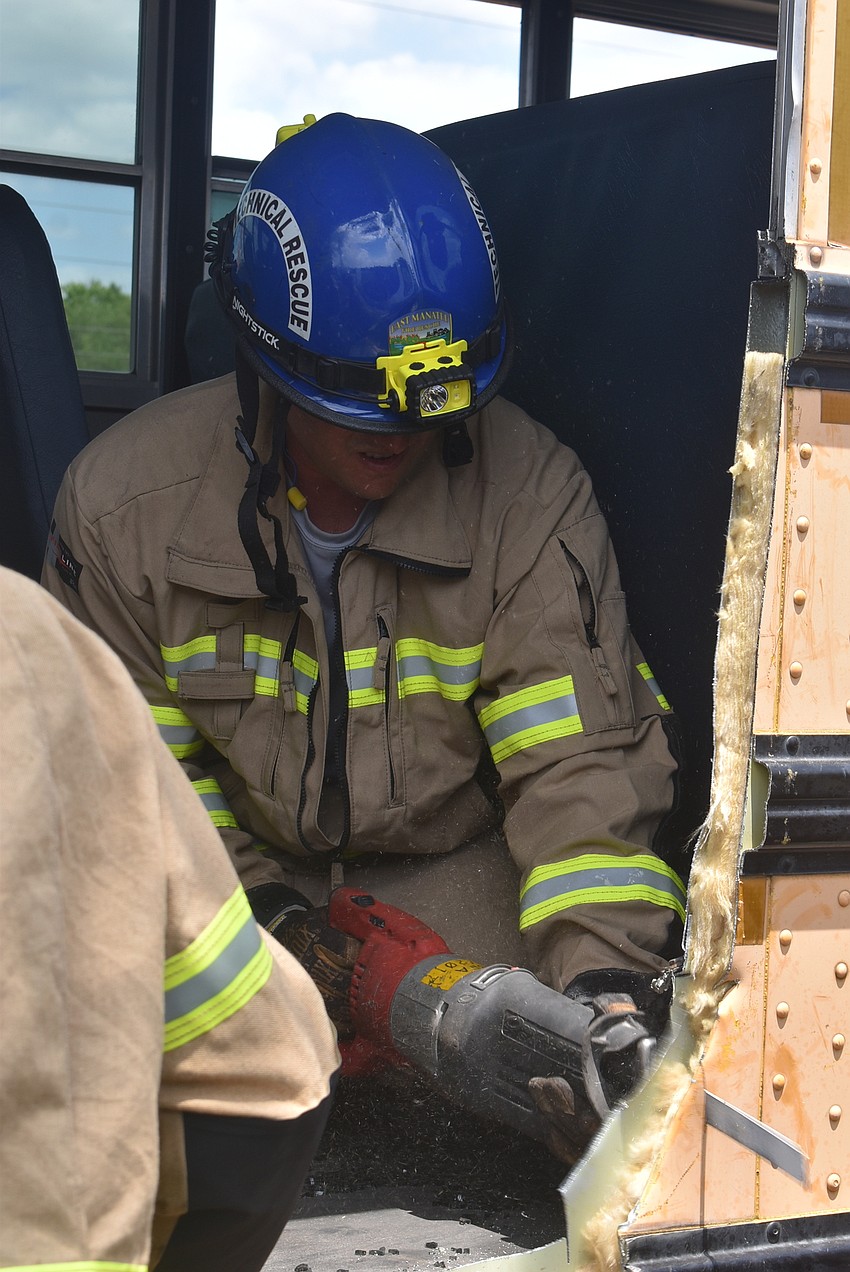 Firefighter Isaac Libby cut through this school bus to create a safer launching point for theoretical children evacuating the bus.