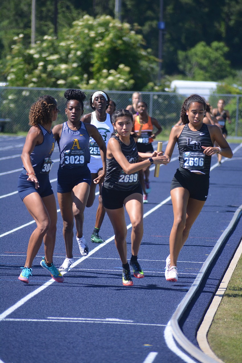 Lakewood Ranch junior Ariana Majaro receives a handoff from junior teammate Maya Bridgeford during the Class 4A girls 4x800 relay. The Mustangs would finish second (9:15.87).