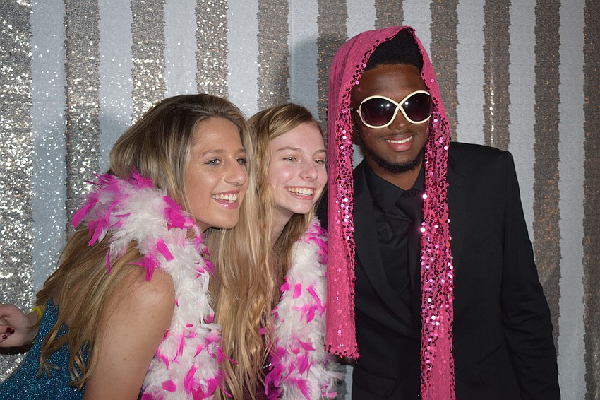 Seniors Bella Crisci, Elizabeth Hescock and Clay Green commemorate their prom at a photo booth.
