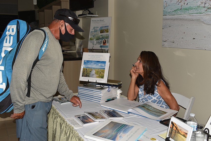 Sammy Avilas, a teaching pro at the Tennis Gardens, gets a book signed by Mary Lou Johnson
