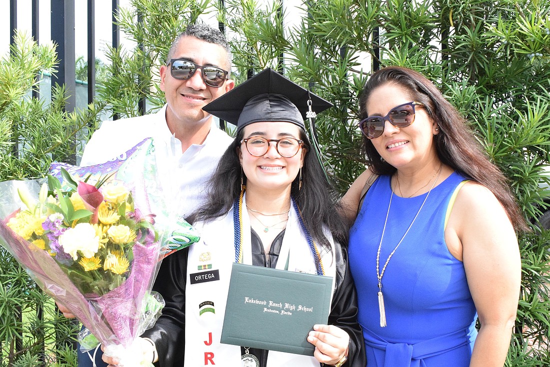 Roberto Ortega and Margo Valenzuela give their daughter Athzira Ortega flowers and balloons to celebrate her graduation from Lakewood Ranch High School last year. More guests will be allowed to attend this year&#39;s ceremonies.
