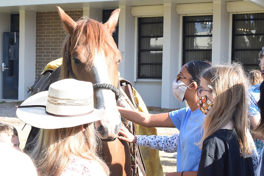 Cady Jones, 10, holds onto Spade, as Gene Witt Elementary School fourth graders Johanna Smith and Clair Craciun pet Spade.