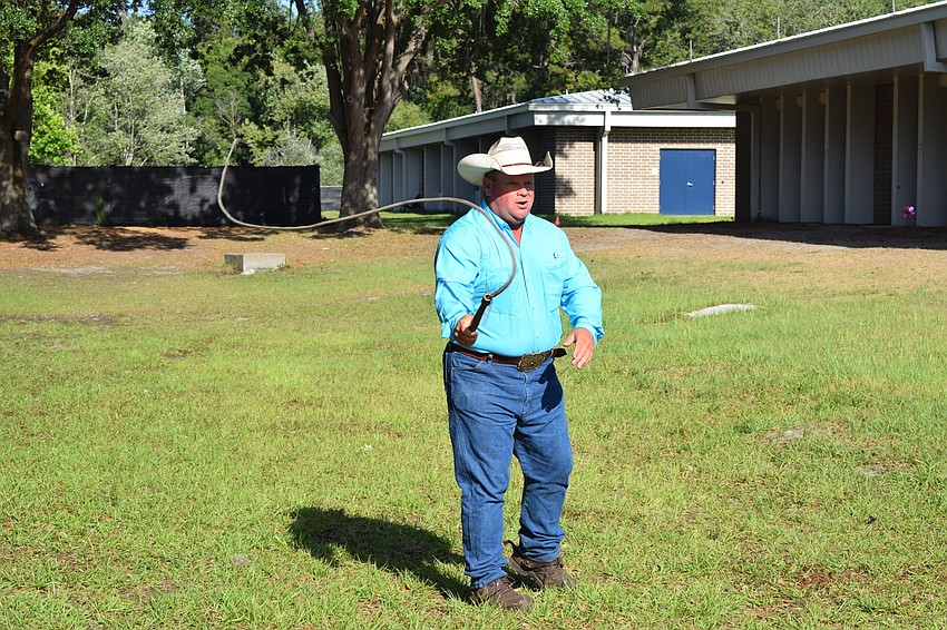 Brian Jones, the ranch manager at Blackbeard's Ranch, cracks a whip to show students the sound it makes, which helps keep the cattle together.
