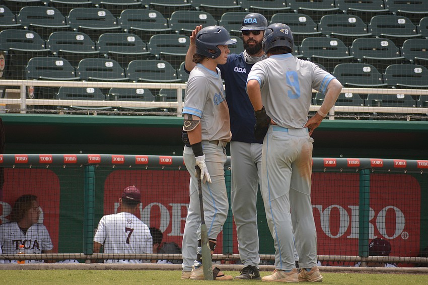 ODA Coach Mike Matthews talks to junior Carter Dierdorf and senior Tanner Fairchild.