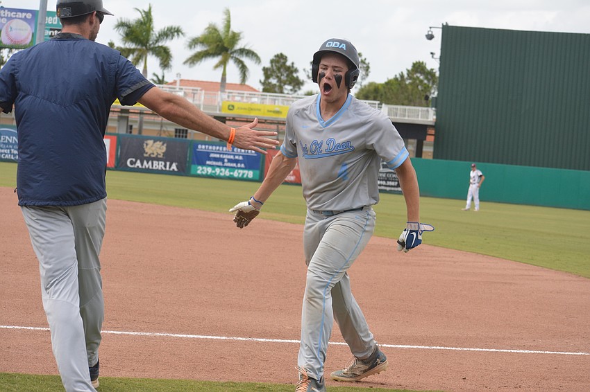 ODA senior Ryan Kelly gives a high five after reaching first base on a bunt in the seventh inning.