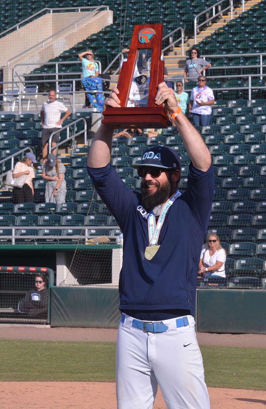 ODA Coach Mike Matthews hoists the team's Class 2A championship trophy.