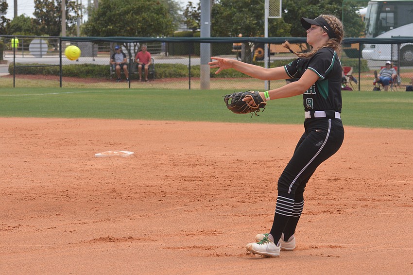 Lakewood Ranch junior Kelsey Vogel tosses a ball to first base while falling backwards.