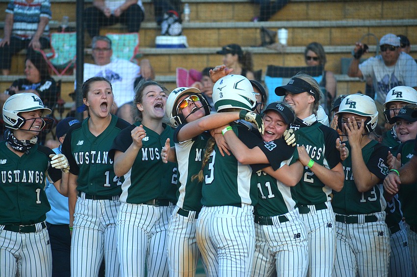 The Mustangs greet sophomore Cassidy McLellan (3) at home plate following McLellan's game-ending triple.