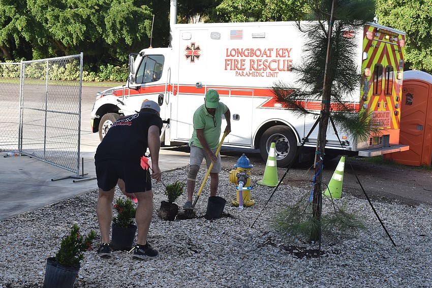 Jim Brown digs a new hole as a fire rescue vehicle heads off to a call.