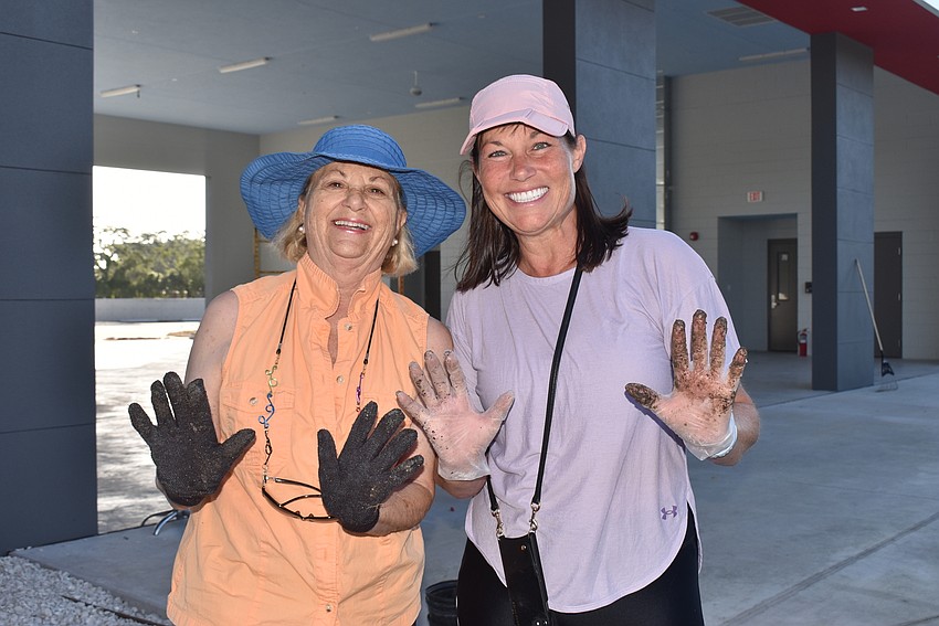 Carole Shawn and Nancy McLean show off their dirt-covered hands.