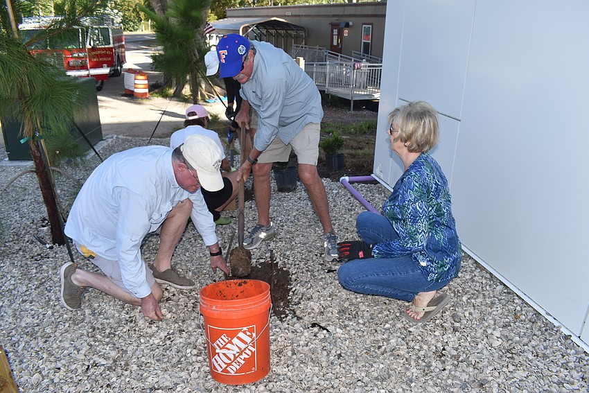 Steve Branham, Mike Haycock and Kathleen Wingate work together on one plant.