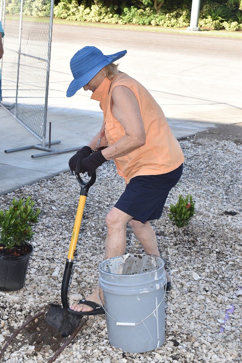 Carole Shaw works to dig up soil.