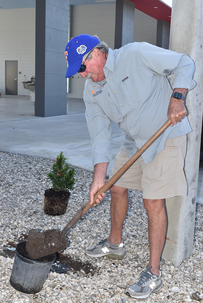 Mike Haycock drops dirt in.