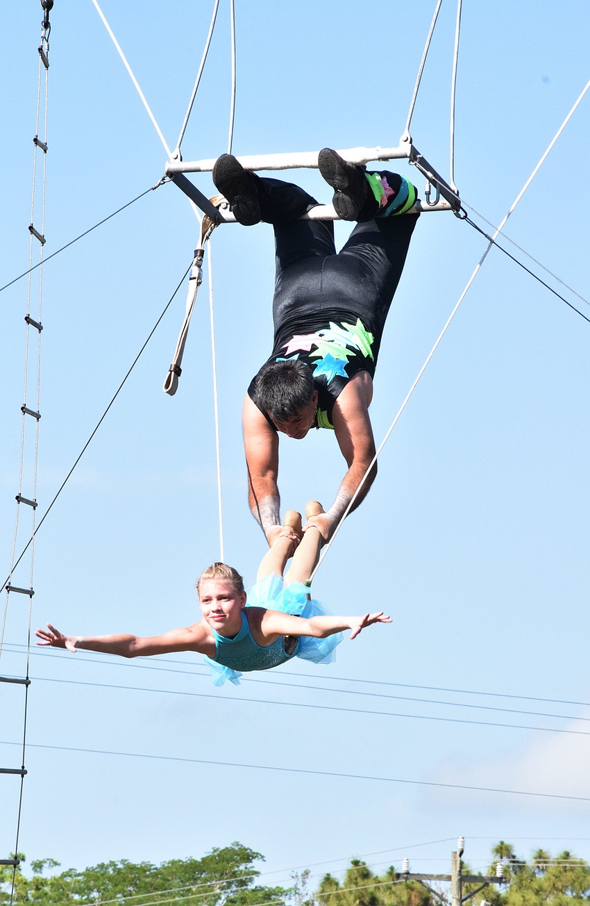 Willy Pages holds onto Cait O'Bryant as she flies through the air during an aerial cradle routine.