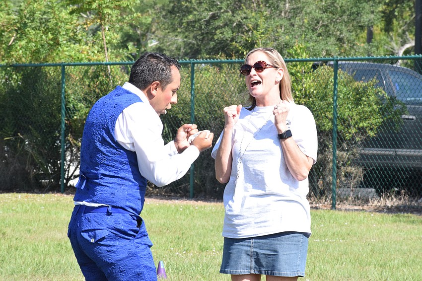 Yvinson Acero with Circus on the Ranch scares Gena Case, the guidance clerk at Myakka City Elementary School, by popping a balloon in front of her.