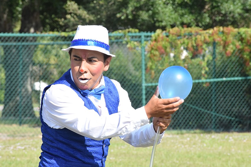 Yvinson Acero with Circus on the Ranch prepares to blow up a balloon to give to a member of the audience.