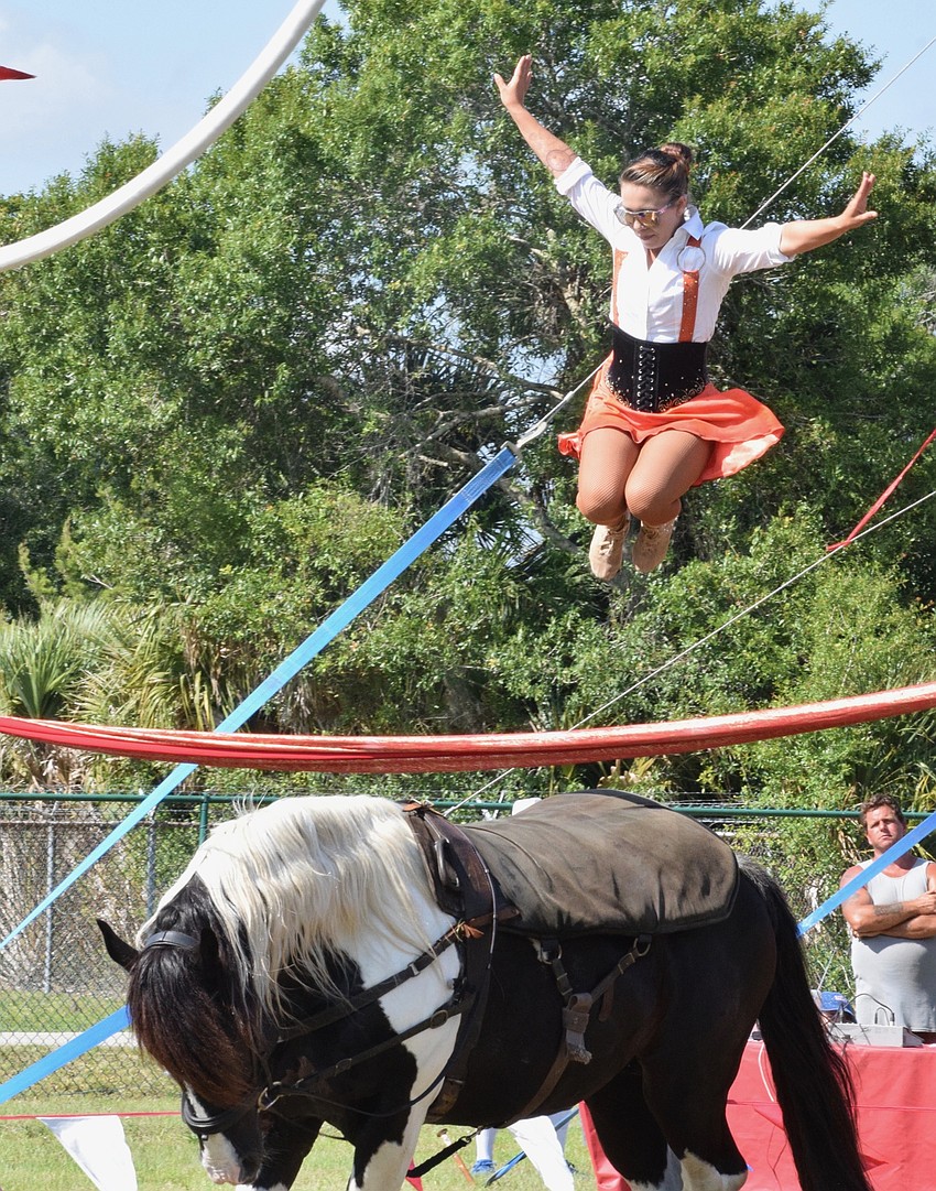 Mercedes Pages with Circus on the Ranch jumps over a large ribbon while riding a horse.