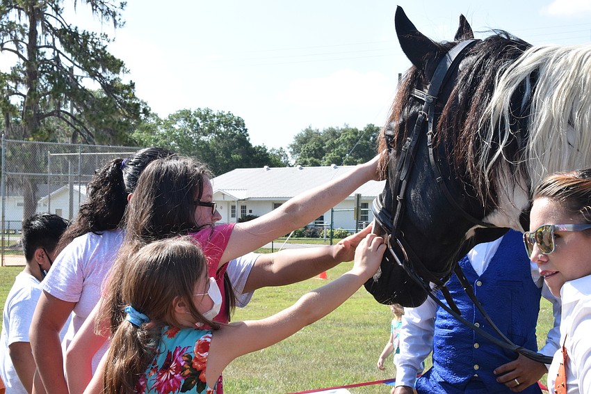 Fifth graders Baylee Case and Bella Reed pet Pinto the horse.
