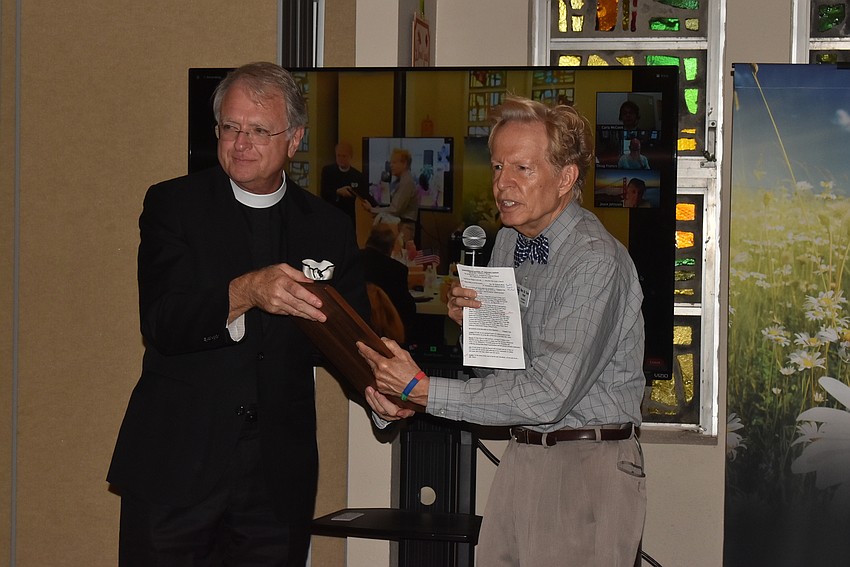 Father Fred Robinson passes the Good and Faithful Servant Award forward.