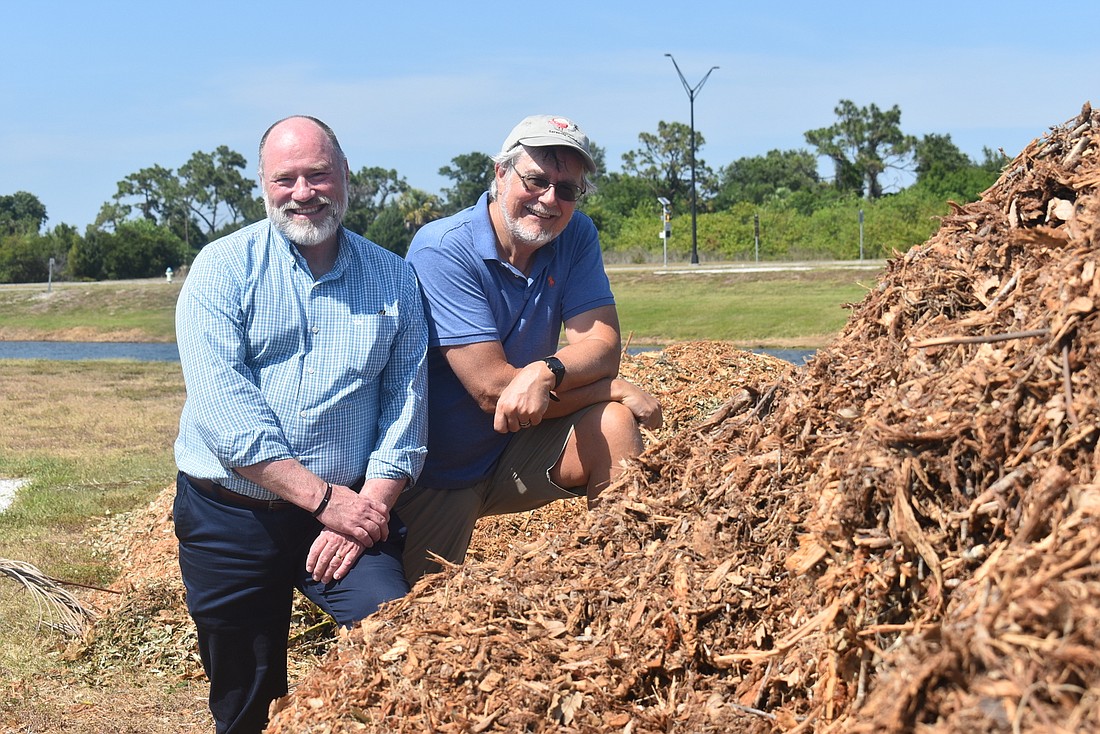 Suncoast Aquatic and Nature Center Associates President and CEO TomÃ¡s Herrera-Mishler and Southface Institute Science Advisor Charles Reith stand with a pile of mulch that will soon be used as the foundation for a microforest.