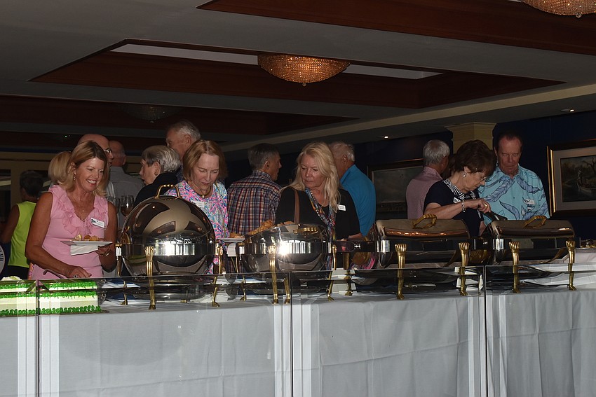 Attendees grabbed light bites from a table before the cake was cut.