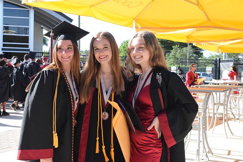 Graduates Anastasia Beasley, Karlie Alfen and Elizabeth Ebury gather as someone takes a photo of them to commemorate their graduation day.