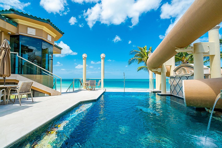 The infinity pool features a waterslide from the rooftop deck.