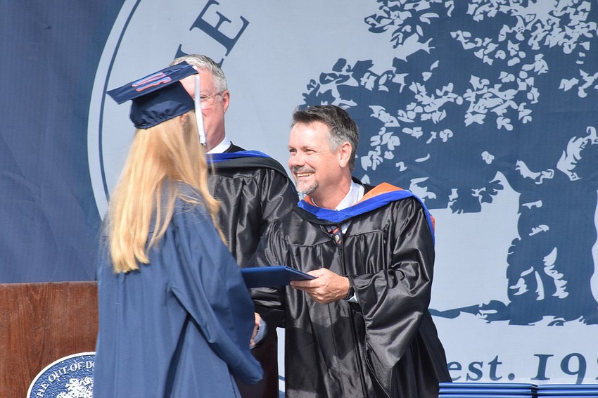 Senior Chelsea Ball accepts her diploma from her father, Sean Ball, the head of upper school.
