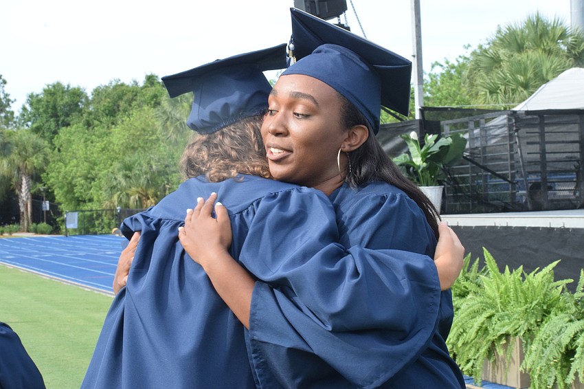 Senior Reece Whatmore hugs senior Jenna Viard after Viard gives her speech as the senior speaker.