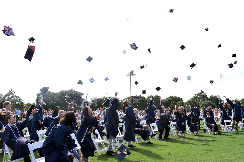 The Out-of-Door Academy graduates throw their caps in the air.