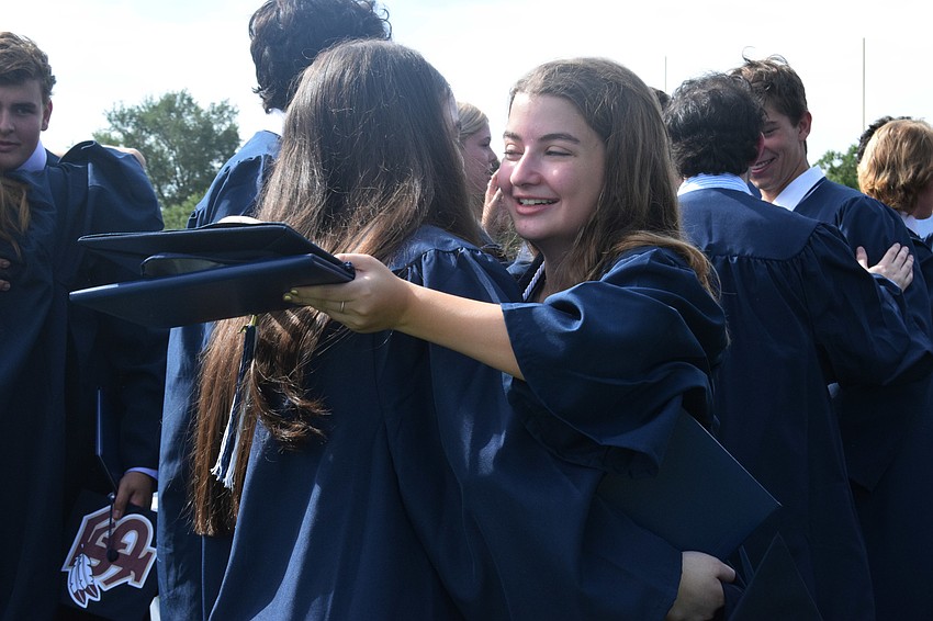 Graduate Alanna Kennedy hugs fellow graduate Margaret Buck.