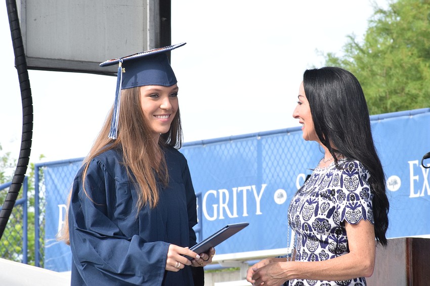 Senior Katrina Crosley smiles as she accepts her diploma from Ashley Kozel, the chair of the Out-of-Door Academy's Board of Trustees.