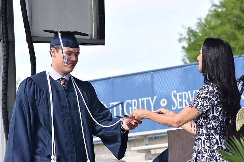 Senior Ryan Kelly accepts his diploma from Ashley Kozel, the chair of the Out-of-Door Academy's Board of Trustees.