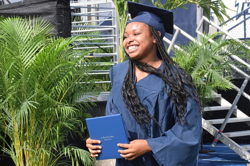 Graduate Saraiah Walkes smiles as she makes her way back to her seat with her diploma in hand.