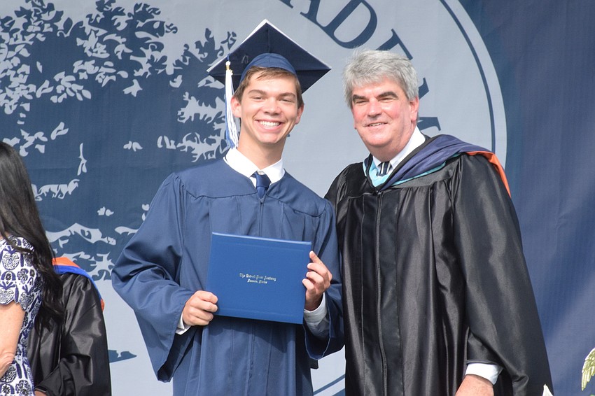 Senior Tyler Beasley is congratulated by David Mahler, the head of school.